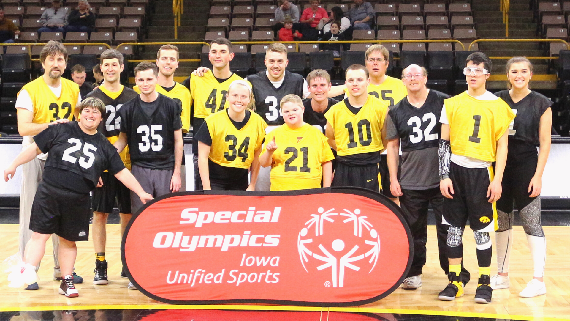 A group of people in sports uniforms celebrating at the Special Olympics