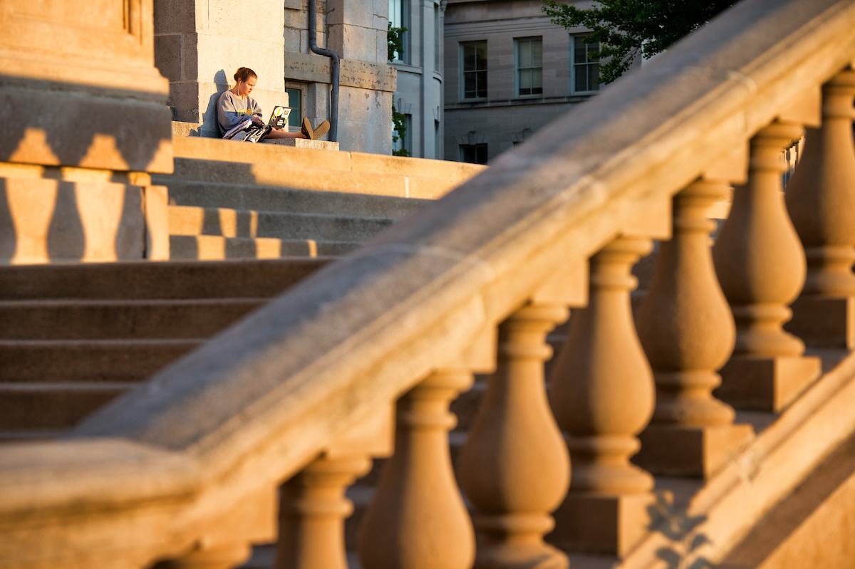 A student studying on the steps of the Old Capitol Building