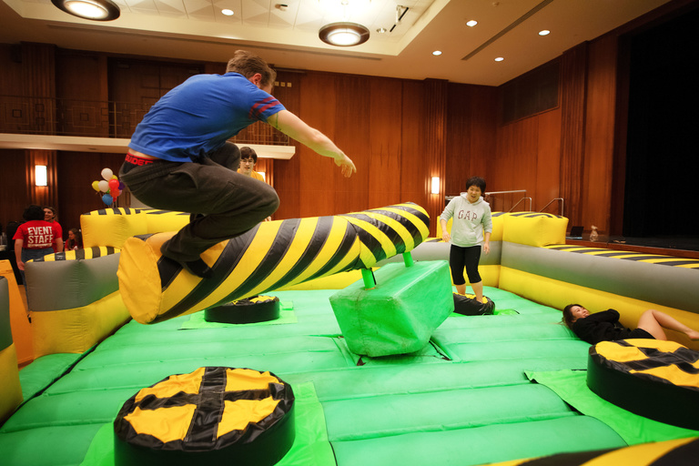 students playing in inflatable obstacle course