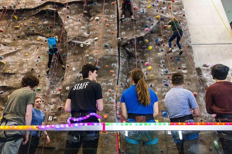 students looking up at a rock climbing wall