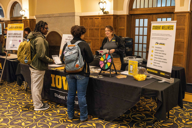 students at a student wellness information table about mental health