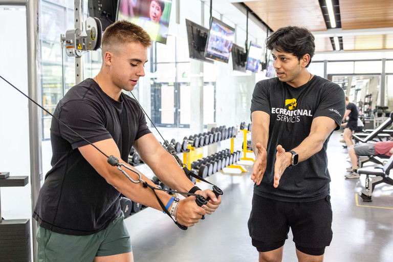 Personal trainer guides their client during training session