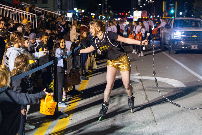 A member of Iowa Waterski and Wakeboard high-fives onlookers during the Homecoming Parade.