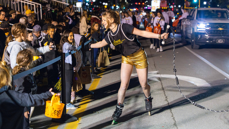 A member of Iowa Waterski and Wakeboard high-fives onlookers during the Homecoming Parade.
